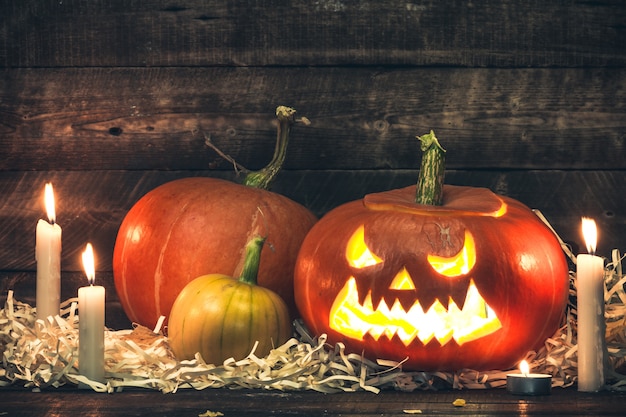 Citrouilles d'Halloween et des bougies sur un fond en bois. Fête d'Halloween. Joyeux Halloween