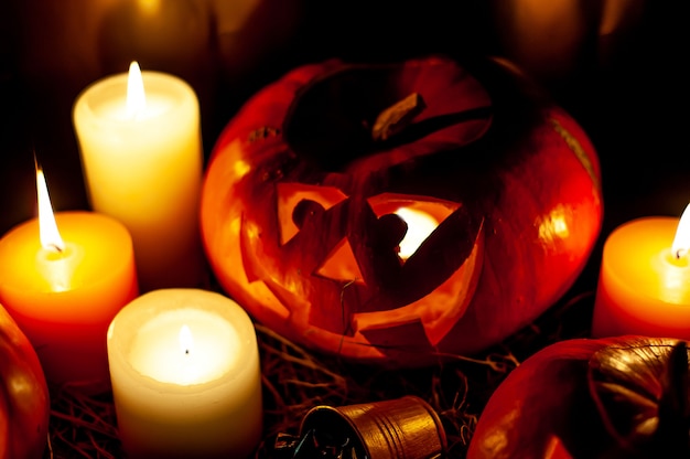 Photo citrouilles d'halloween et bougies sur une pièce sombre