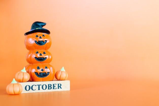 Citrouilles d'Halloween (Jack-o'-lantern) sur fond orange, concept Bonjour Octobre