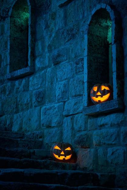 Citrouilles d'Halloween jack p lanterne dans la cour d'un vieux château la nuit au clair de lune