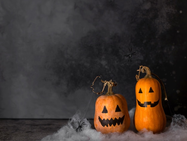 Citrouilles d'Halloween avec visages peints et toile d'araignée