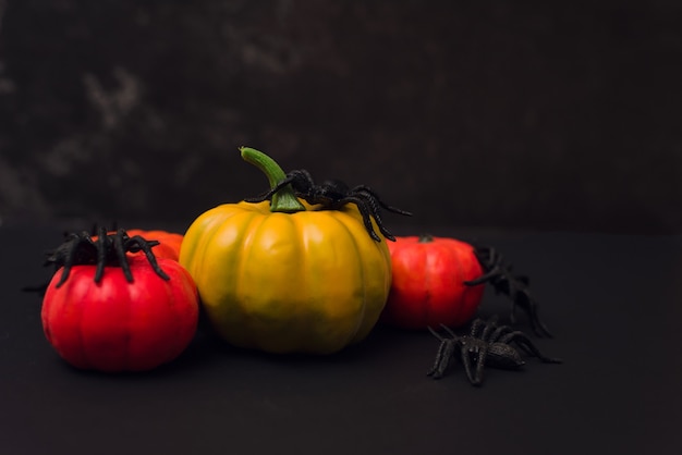 Citrouilles orange d'Halloween avec des araignées. Joyeux halloween sur fond noir