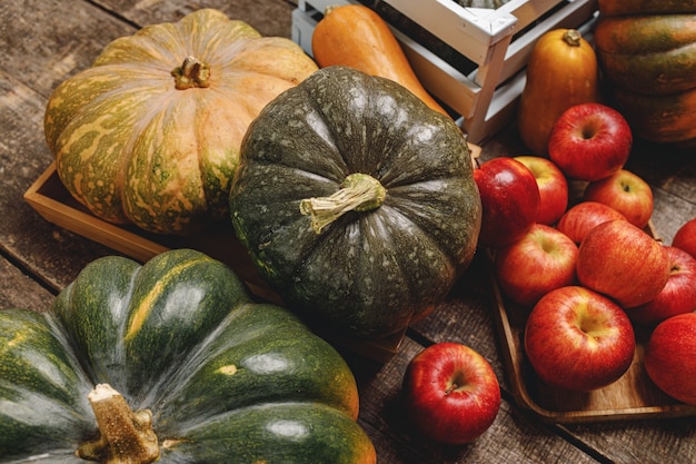 Citrouilles et pommes rouges sur fond en bois grunge