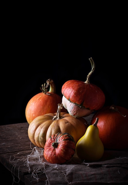 Citrouilles sur une table en bois sur fond sombre