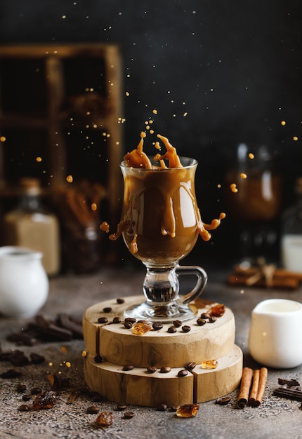 Éclaboussure de café sur fond marron avec des grains de café