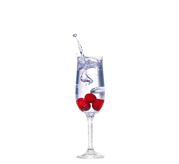Éclaboussure de cerise dans un verre à cocktail sur blanc