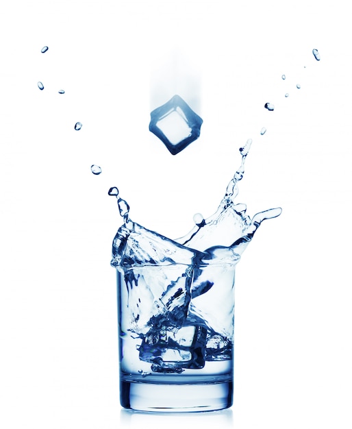 Éclaboussure d'eau dans un large verre avec une glace volante