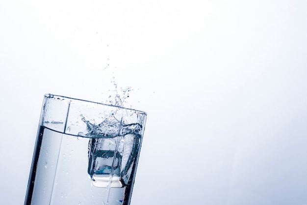 Éclaboussure d'eau dans un verre d'un glaçon.