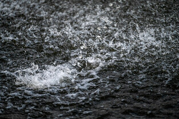 Éclaboussure d'eau avec de petites gouttes dans la fontaine abstraite fond de mise au point sélective naturelle