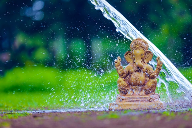 Éclaboussure d'eau sur la sculpture du seigneur ganesha. célébrer la fête du seigneur ganesha.