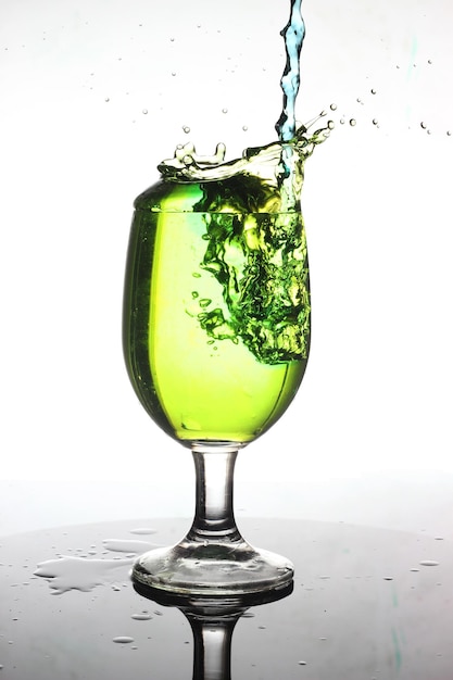 Éclaboussure d'eau verte dans un verre à vin