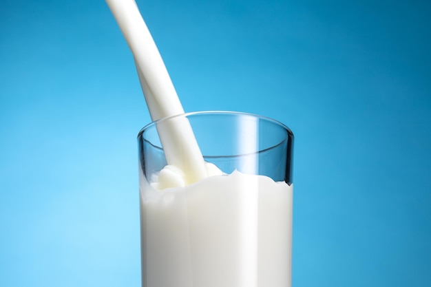 Éclaboussure de lait dans un verre sur fond bleu