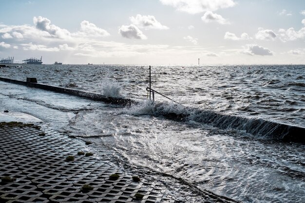 Éclaboussure d'une vague sur le remblai inondé près de la mer