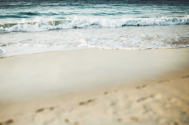 Éclaboussures d&#39;eau bleue sur la plage de sable