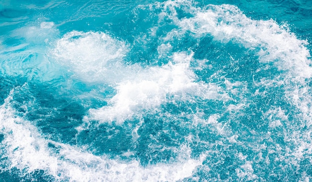 Éclaboussures d'eau de mer bleue avec des bulles de mousse Une touche de nature un jour d'été fond de mer bleue avec des éclaboussures d'eau