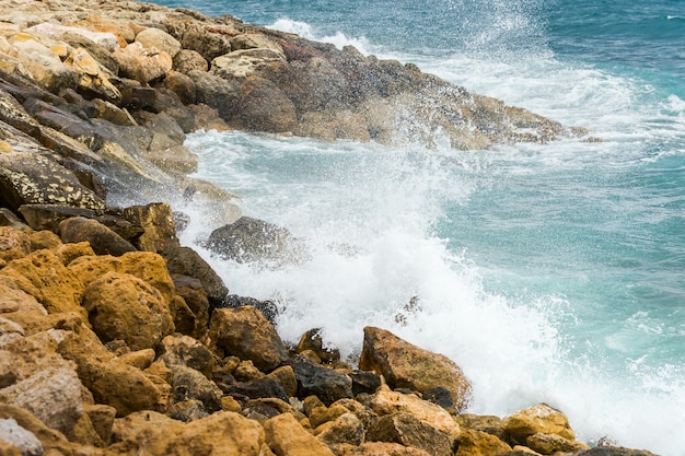 Éclaboussures d'eau de mer s'écrasant sur les rochers côtiers