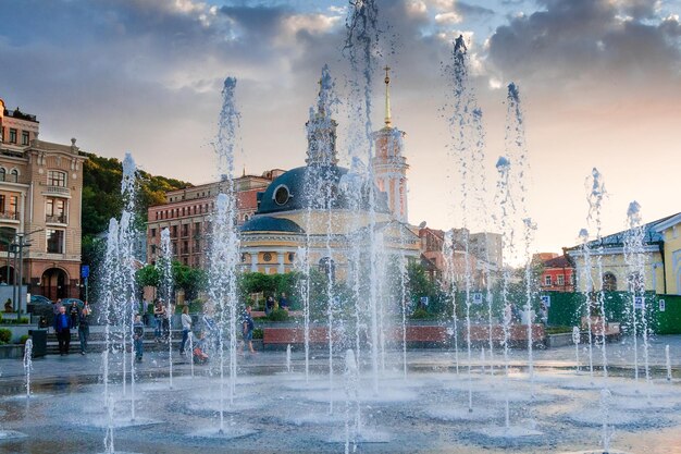 Éclaboussures d'une fontaine sur fond de ville et un beau coucher de soleil