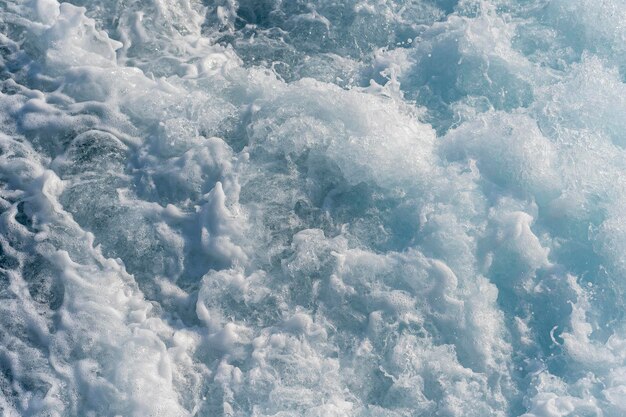 Éclaboussures de gouttes d'eau de mer bleue pendant le mouvement du navire