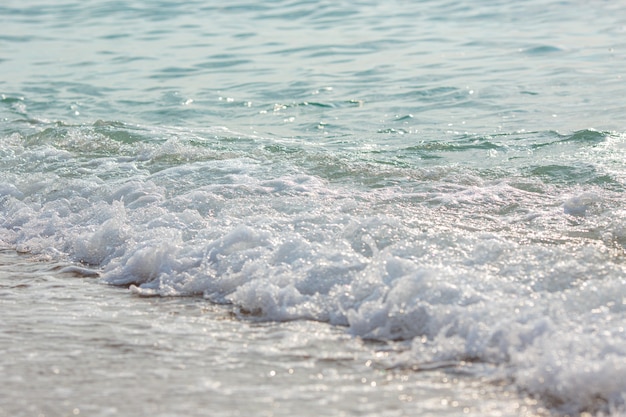 Éclaboussures de la marée, gros plan de l'eau turbulente. Surface des vagues de la mer, éclaboussures, mousse et bulles à marée haute et surf, fond abstrait aqua