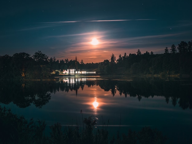 Photo clair de lune sur un lac avec un château