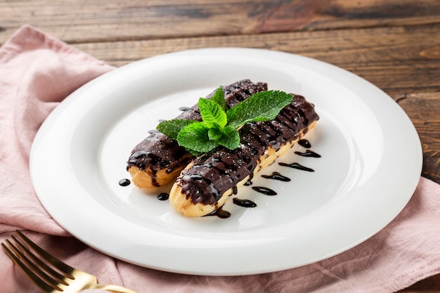 Éclairs avec garniture au chocolat sur assiette de service