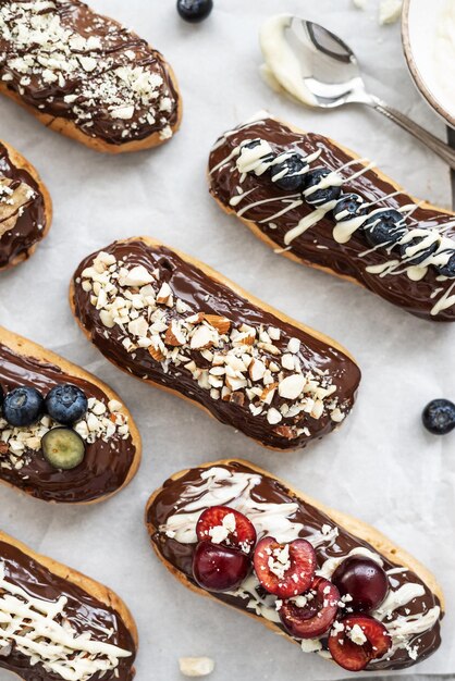 Éclairs avec garniture au chocolat noix et baies sur fond de béton