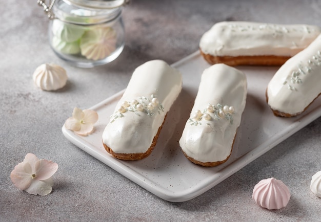 Éclairs de glaçure blanche sur plateau de service blanc. Délicieux dessert français. mise au point sélective