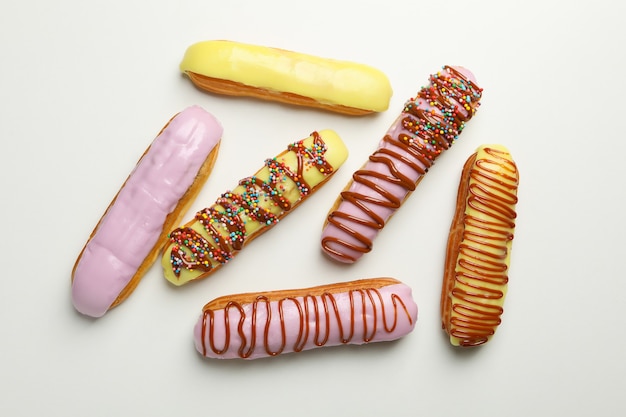 Éclairs savoureux avec garniture différente sur blanc