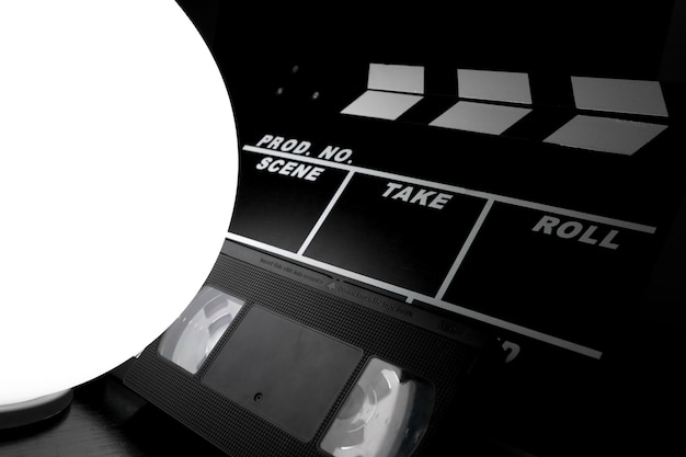 Clap de film avec une sphère de lumière blanche et une cassette VHS