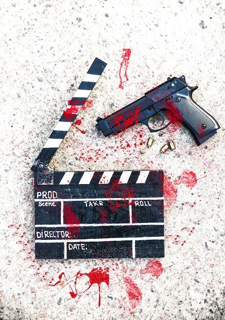 Photo clap noir avec pistolet sur fond. réalisation et tournage de film de cinéma. histoire criminelle de détective.