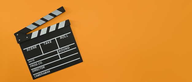 Un clapper board sur fond orange avec espace de copie Concept minimal de cinéma