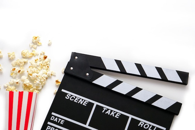 Clapperboard ou ardoise de film couleur noire avec du pop-corn sur fond blanc
