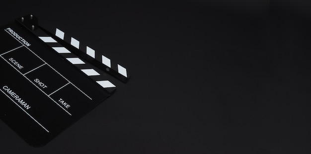 Clapperboard ou clap board ou utilisation d'ardoise de film dans la production vidéo, le cinéma, l'industrie du cinéma sur fond noir.