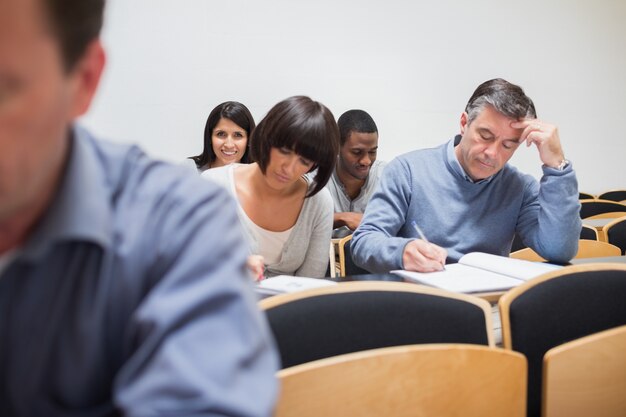 Classe adulte prenant des notes