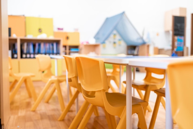 Photo classe de maternelle colorée sans jouet de chaise de bureau d'éducation scolaire pour enfants et décoration sur le mur de fond