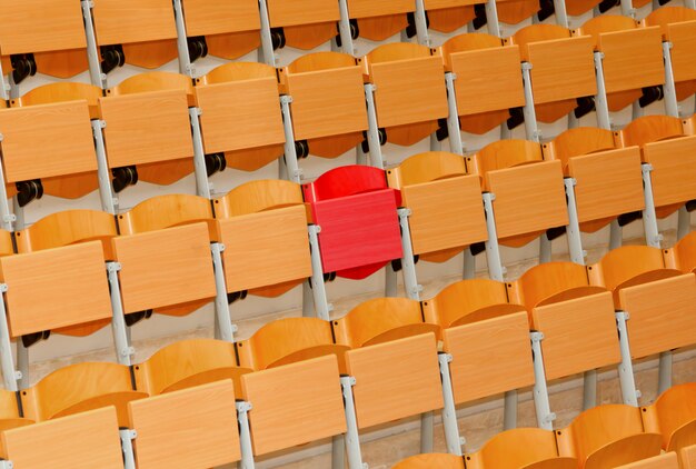 Classe vide avec chaises en bois et une chaise rouge