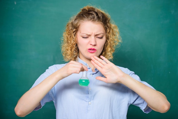 Classes de lycée. Étudiant effectuant une réaction chimique. Liquide chimique qui sent vraiment mauvais. Expérience dégoûtante. Une étudiante n'aime pas la chimie. Étudiant pratiquant sur une leçon haineuse.