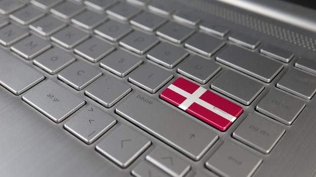 Photo le clavier avec le drapeau du danemark sur le bouton d'entrée représente le langage d'apprentissage de la cyberattaque