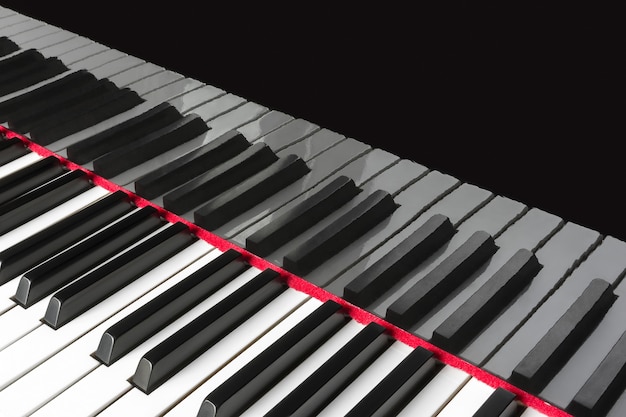 Le clavier du piano à queue se reflète dans la surface laquée du couvercle