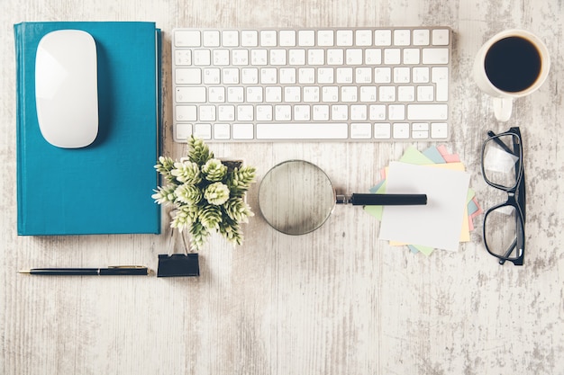 Clavier avec livre et loupe sur le bureau