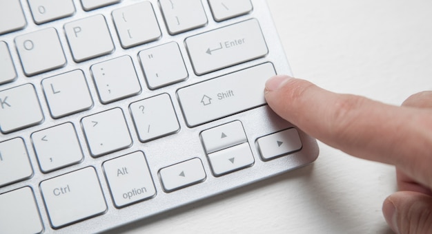 Photo clavier d'ordinateur avec le doigt appuyant sur le bouton.