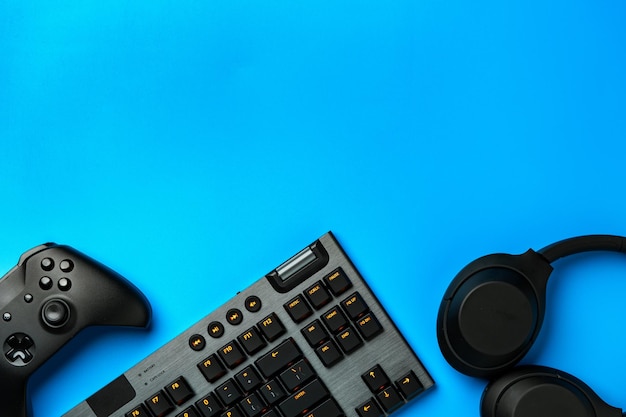 Photo clavier d'ordinateur et joystick sur fond bleu vue supérieure