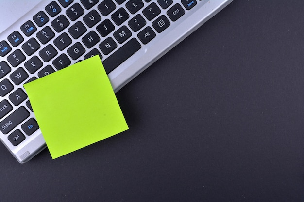 Clavier d'ordinateur avec un post-it vierge pour votre message personnalisé