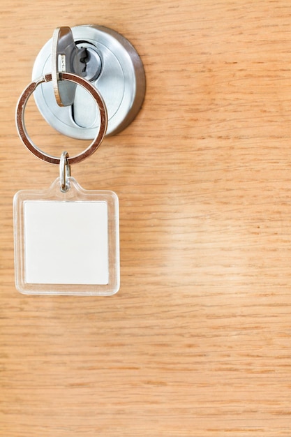 Photo clé d'accueil avec porte-clés carré vide dans la serrure