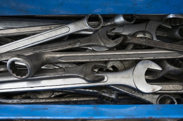 Clé ancienne et sale, clé mixte dans une boîte à outils bleue