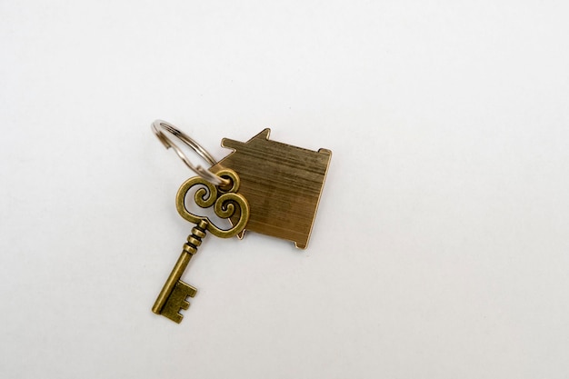 la clé de l'appartement avec un trousseau en forme de maison sur fond blanc