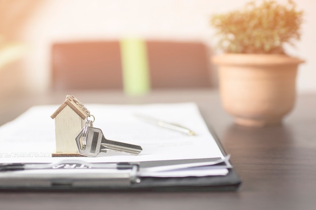 Photo clé de la maison sur papier contract prépare pour le propriétaire sur la table