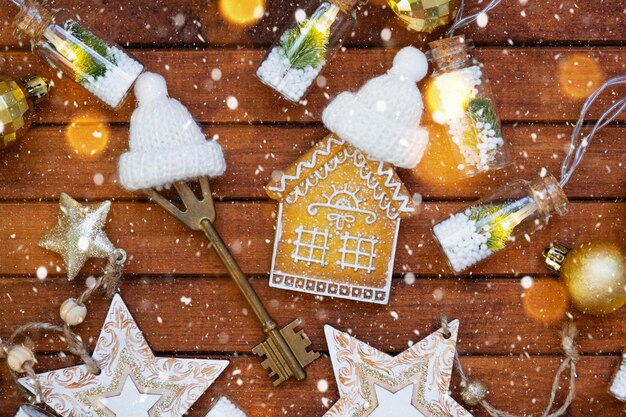 Clé de la maison avec un porte-clés petite maison sur fond de bois avec disposition de décoration de Noël