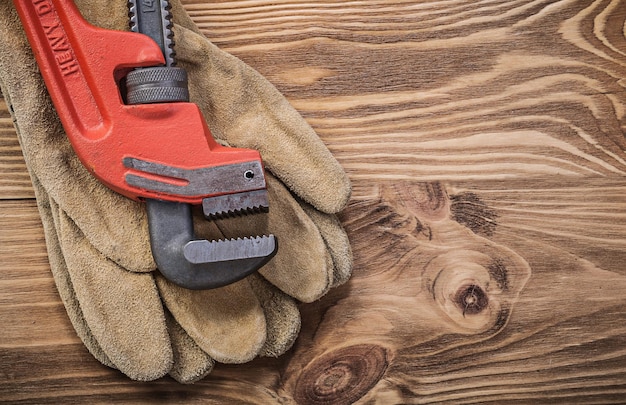 Clé à pipe de gants de protection sur le concept de construction de planche de bois