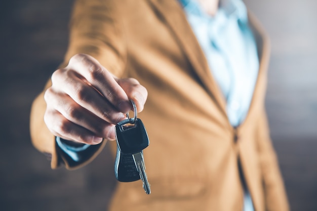 Clé de voiture main homme sur fond sombre